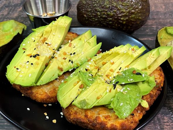 Smashed avocado on toasted gluten-free bread topped with chili flakes and lemon.